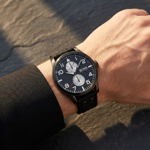 Close up of Hugo Boss Aeroliner Maxx 1513086 on wrist showing black woven dial and synthetic fiber strap with signature metal rivets 50m water resistance