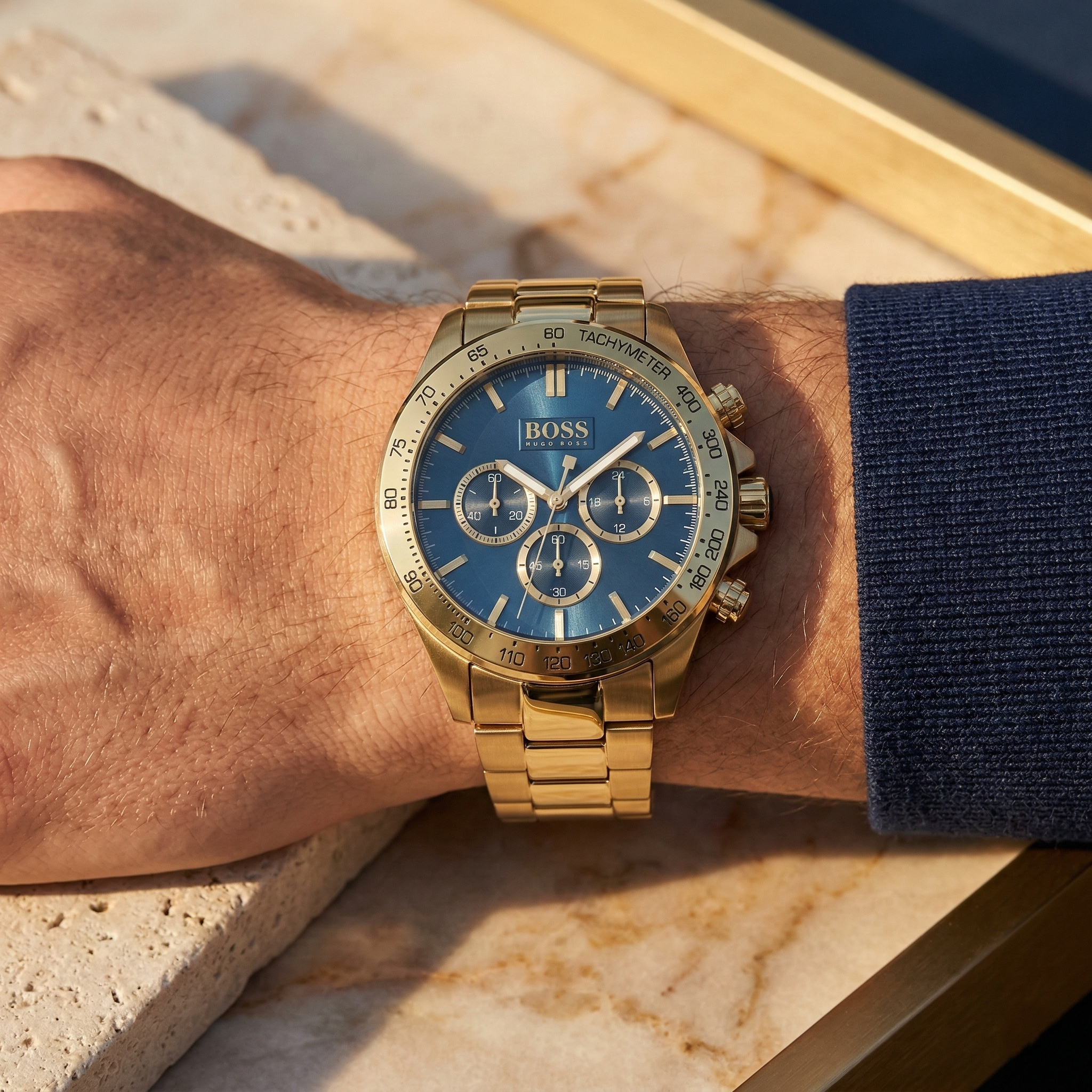 Close up of Hugo Boss Ikon 1513340 on wrist showing blue dial and gold metal strap with 100m water resistance