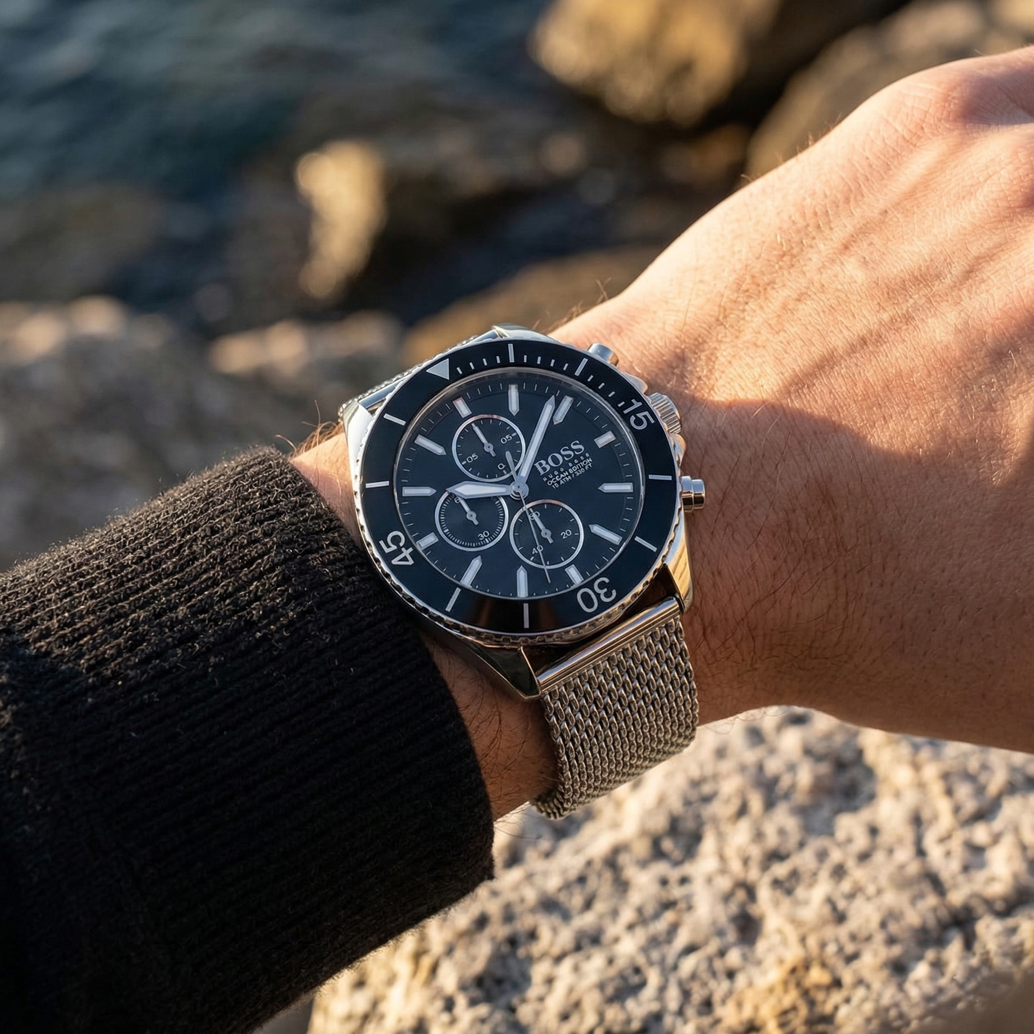 Close up of Hugo Boss Ocean Edition 1513701 on wrist showing black dial and silver metal mesh strap with 100m water resistance