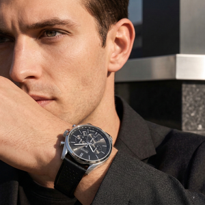 Professional man wearing Hugo Boss Champion 1513816 with black dial and silver case leather strap water resistant 100m