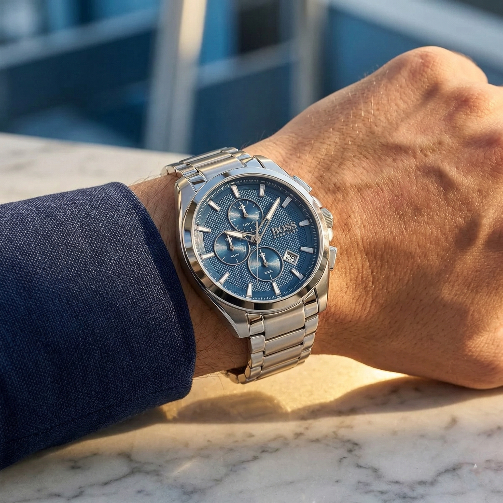 Close up of Hugo Boss Grandmaster 1513884 on wrist showing blue dial and silver metal link strap with 50m water resistance