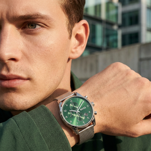 Professional man wearing Hugo Boss Skymaster 1513938 with green dial and silver metal mesh strap water resistant 50m