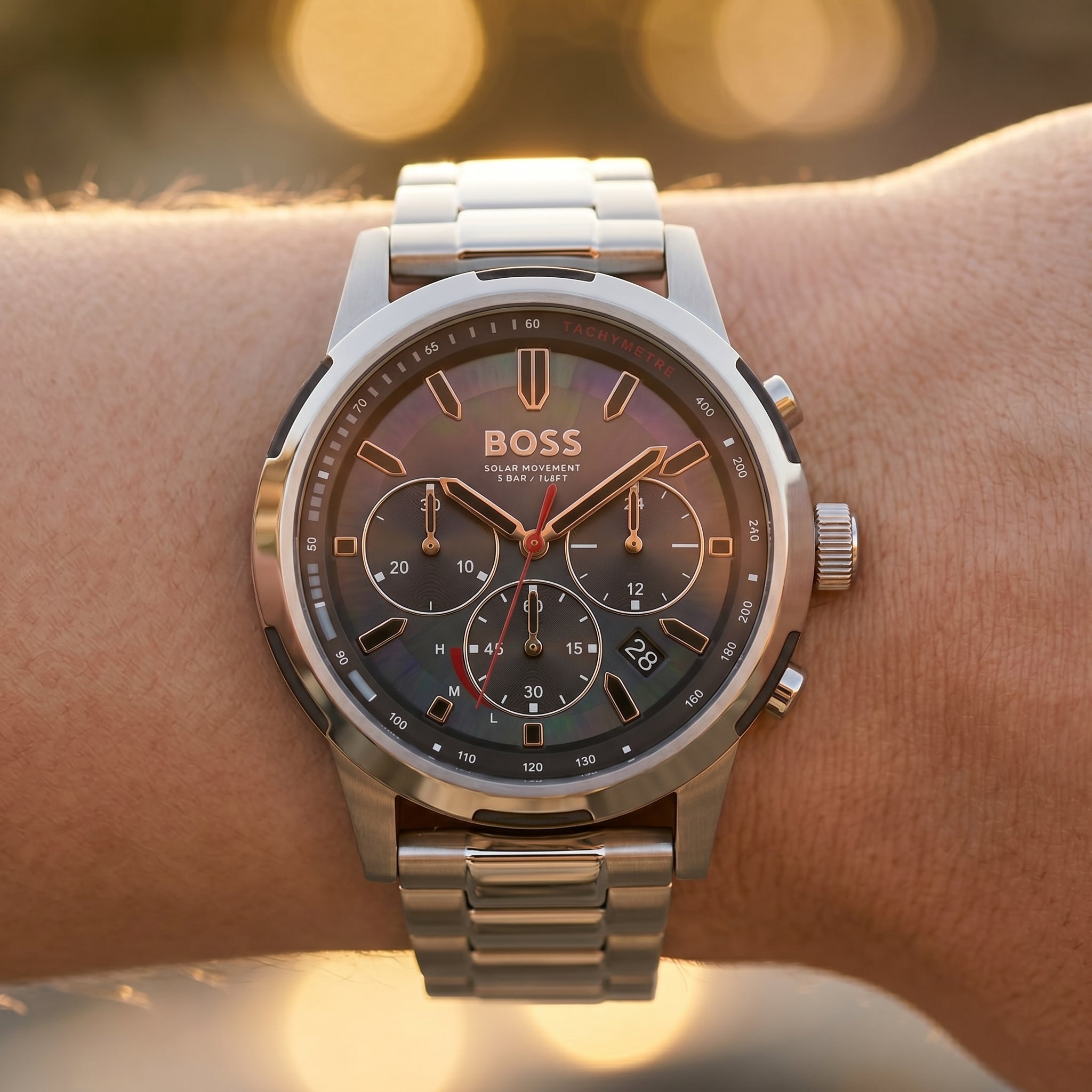 Close up shot of Boss Solgrade 1514032 on wrist showing the polished silver case and black tachymeter bezel from Luxury Hub Store