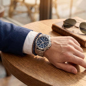 Lifestyle photo of Boss Troper 1514069 showing the bold silver watch on a man's wrist in an active outdoor setting from Luxury Hub Store