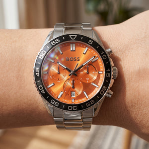 Close up shot of Boss Runner 1514162 on wrist showing the sleek silver case, black bezel and orange sunray dial from Luxury Hub Store