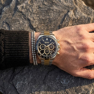Close up of Hugo Boss Hero 1514269 men's quartz battery watch on wrist showing black dial and luxury gold accents