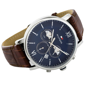 Angled profile left view of Tommy Hilfiger Evan Men's 1710393 watch highlighting dynamic flexible integrated rich brown genuine leather genuine leather strap structure dynamic contrasting white stitch details polished stainless steel buckle clasp central Analogue central minute track dynamic casually luxurious style visual casual dynamic visual casual utility