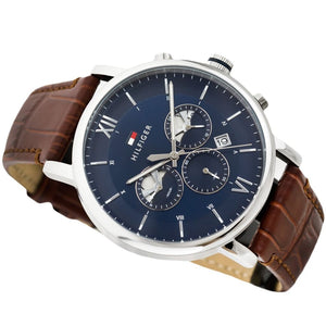Angled profile right view of Tommy Hilfiger Evan Men's 1710393 watch showing polished round silver stainless steel case plain smooth bezel protective crown detailed integrated protected area and textured rich brown genuine calfskin leather strap with white contrast stitching dynamic visually casual utility visual dynamic visual style visual dynamic visual utility dynamic casual utility