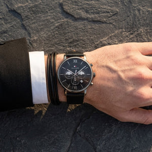 Close up of Tommy Hilfiger Evan 1710395 men's chronograph analog watch dial on wrist angled profile view showing distinct dynamic black sunray dial luminous hands applied gold stick indices gold sub-dials minutes seconds 24-hour time date window dotted central minute track visual dynamic casual luxury jewelry-like appearance dynamic visual dynamic casually luxurious visual style visual dynamic visual dynamic casual luxury visual dynamic visual casual luxury