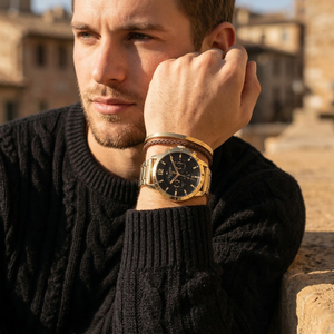 Elegant man wearing Tommy Hilfiger Luca 1710511 men's quartz battery watch with gold-tone case and luxury black dial