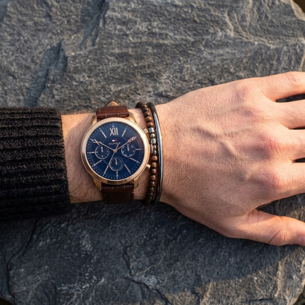 Close up of Tommy Hilfiger Morrison 1710526 men's quartz battery watch on wrist showing navy blue dial and luxury gold-tone markers