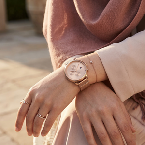 Elegant woman wearing Tommy Hilfiger 1781907 women's quartz battery watch with rose gold case and luxury mesh strap