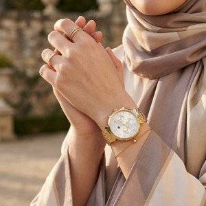 Elegant woman wearing Tommy Hilfiger Ivy 1782344 women's quartz battery watch with gold-tone case and luxury silver dial