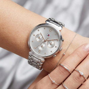 Close up of Tommy Hilfiger Ivy 1782346 women's quartz battery watch on wrist showing gray sunray dial and silver metal bracelet