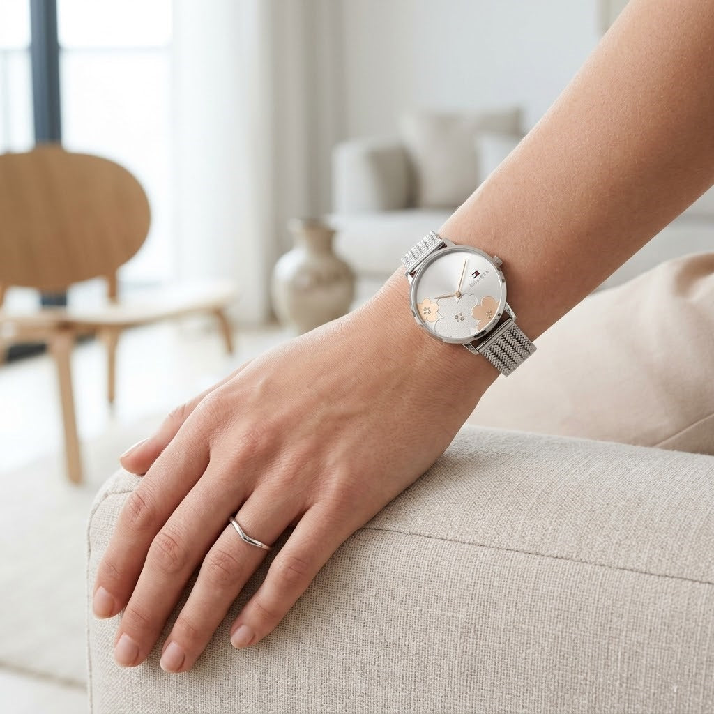 Close up of Tommy Hilfiger 1782604 women's quartz battery watch on wrist showing silver sunray floral dial and luxury mesh bracelet
