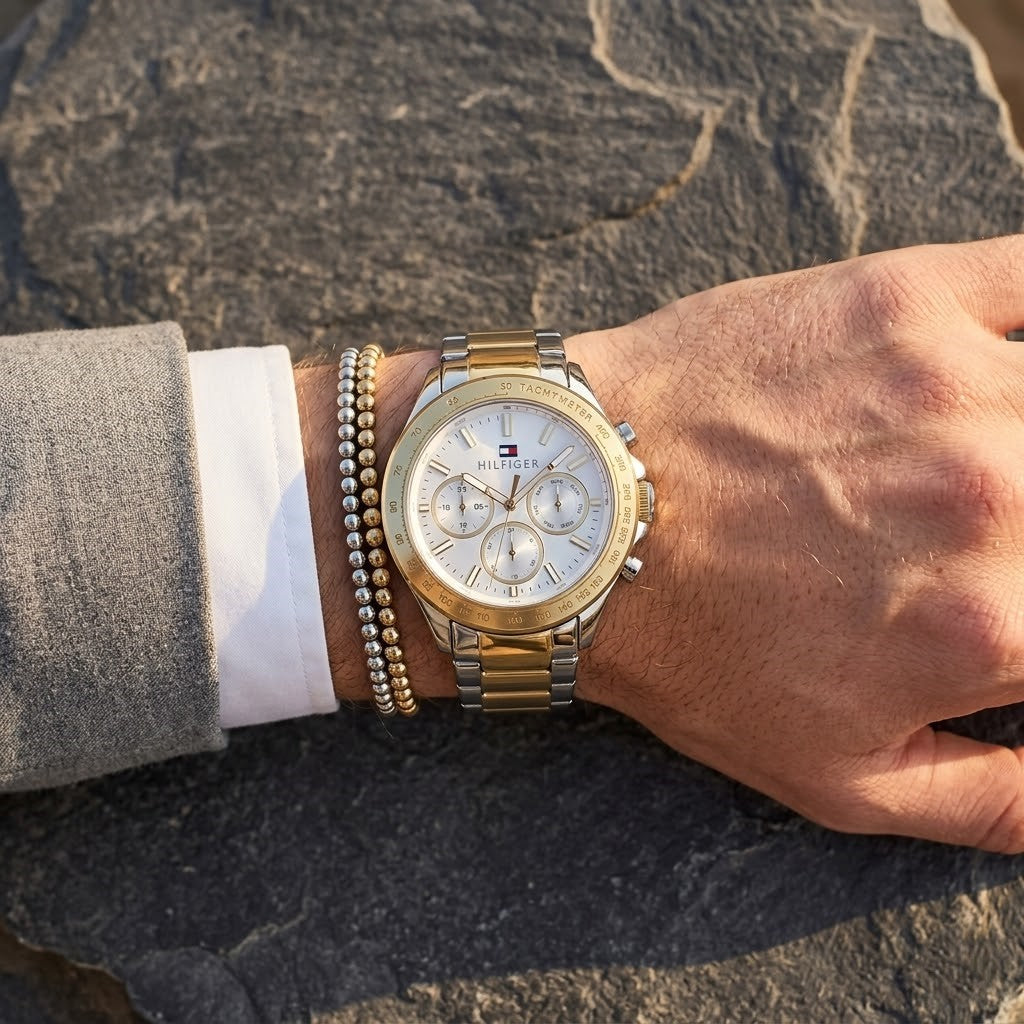 Close-up of Tommy Hilfiger Hudson 1791226 men's analog watch (Silver/Gold Two-Tone variant) dial on wrist angled profile view showing distinct dynamic silver sunray dial dynamic multi-function sub-dials showing day date 24-hour time central Analogue display hands central Analogue central minute track dynamic visual casual luxury
