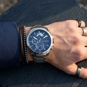 Close up of Tommy Hilfiger Decker 1791348 men's quartz battery watch on wrist showing blue textured multi-function dial and silver metal bracelet