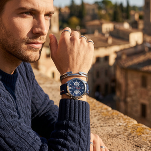 Elegant man wearing Tommy Hilfiger Decker 1791476 men's quartz battery watch with silver-tone case and sporty blue logo strap