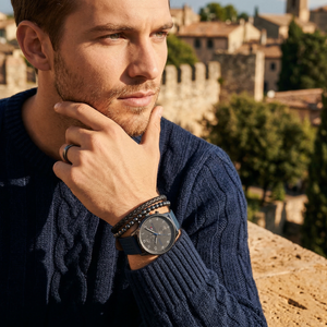 Elegant man wearing Tommy Hilfiger Chase 1791578 men's quartz battery watch with gunmetal case and luxury blue leather strap