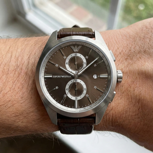 Lifestyle view of man wearing Emporio Armani AR11482 leather watch with brown suit