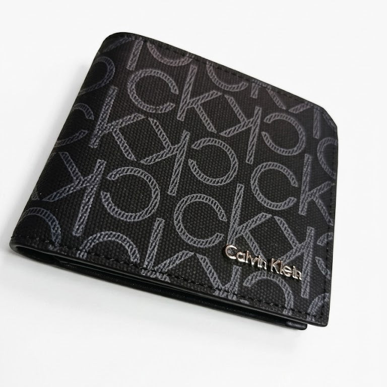 Professional angled studio photograph of the sleek Calvin Klein mirror original black leather bi-fold wallet covered in grey ck monogram