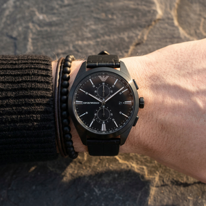Close up of Emporio Armani Claudio AR11483 men's quartz battery watch on wrist showing black chronograph dial and black leather strap