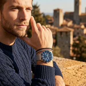Elegant man wearing Emporio Armani Diver AR11587 men's quartz battery watch with silver-tone case and luxury mesh strap