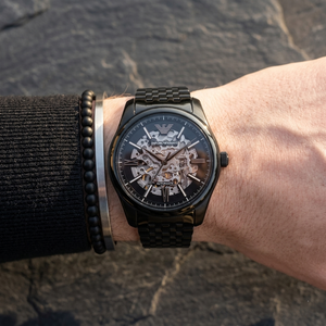 Close up of Emporio Armani Antonio AR60093 men's automatic watch on wrist showing intricate skeleton dial and black metal bracelet
