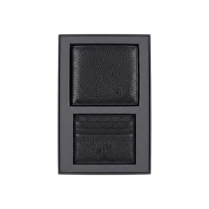 Live smartphone photograph of the Armani Exchange AX mirror original 2-piece gift set showcasing the black leather wallet with silver logo and matching metal keychain inside the custom black and red box tray