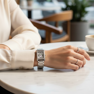 Elegant woman wearing Emporio Armani AR11625 rectangular silver watch with white blazer
