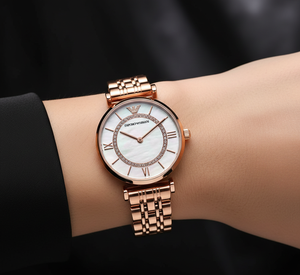 Glamorous woman wearing Emporio Armani AR1909 rose gold watch at evening event