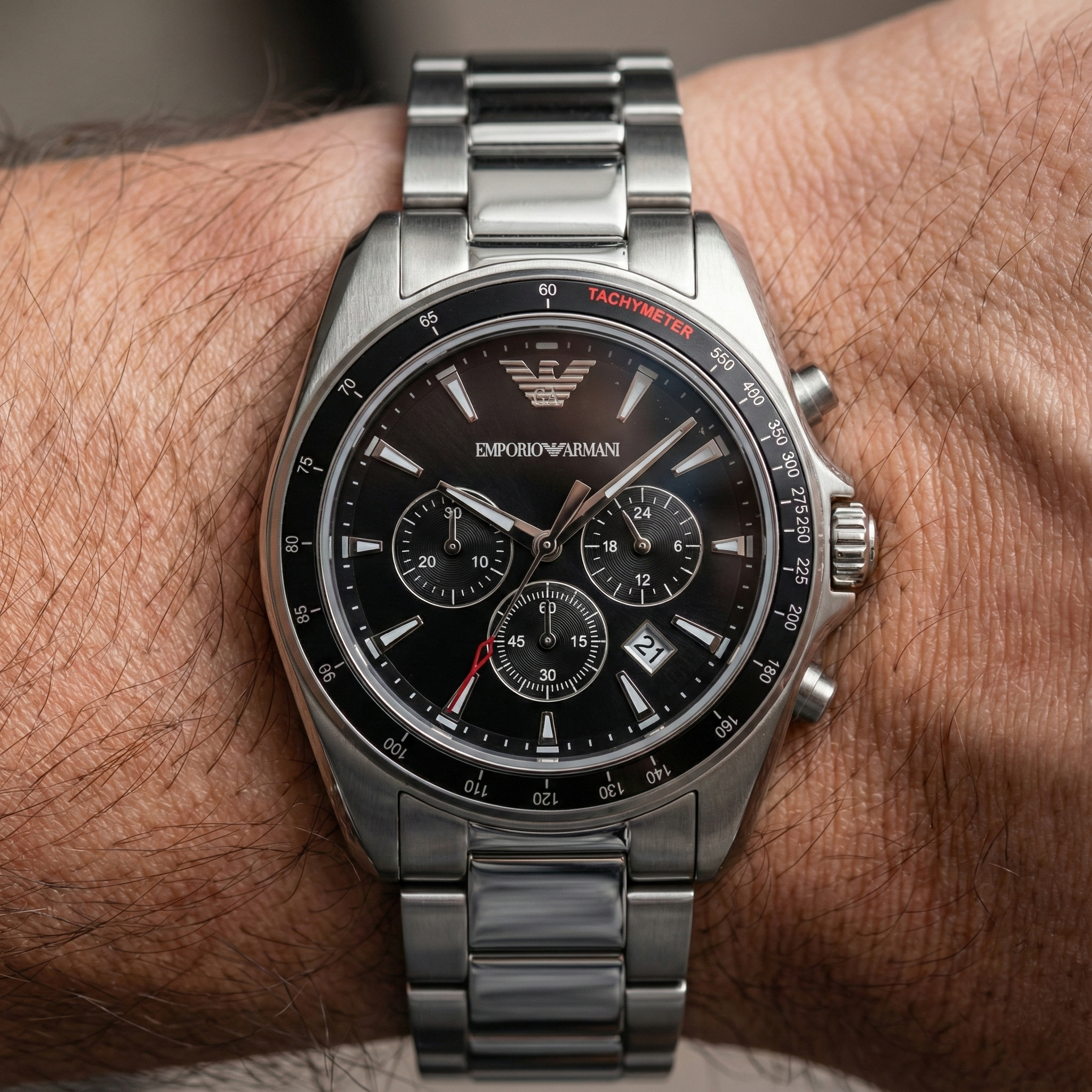 Close up of Armani AR6098 bezel showing red Tachymeter text and black dial