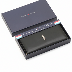 A black leather bifold wallet resting inside its open presentation gift box, with the box cover displayed alongside.
