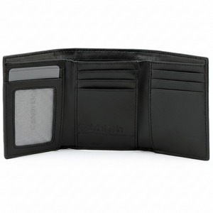 Fully open interior view of a Calvin Klein men's black leather wallet revealing a practical tri-fold design with a clear ID window on the left, multiple card slots, and debossed branding in the center