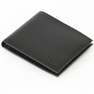 Close-up angled view of a closed Calvin Klein men's black smooth leather bifold wallet highlighting the premium finish and the small debossed Calvin Klein logo in the corner