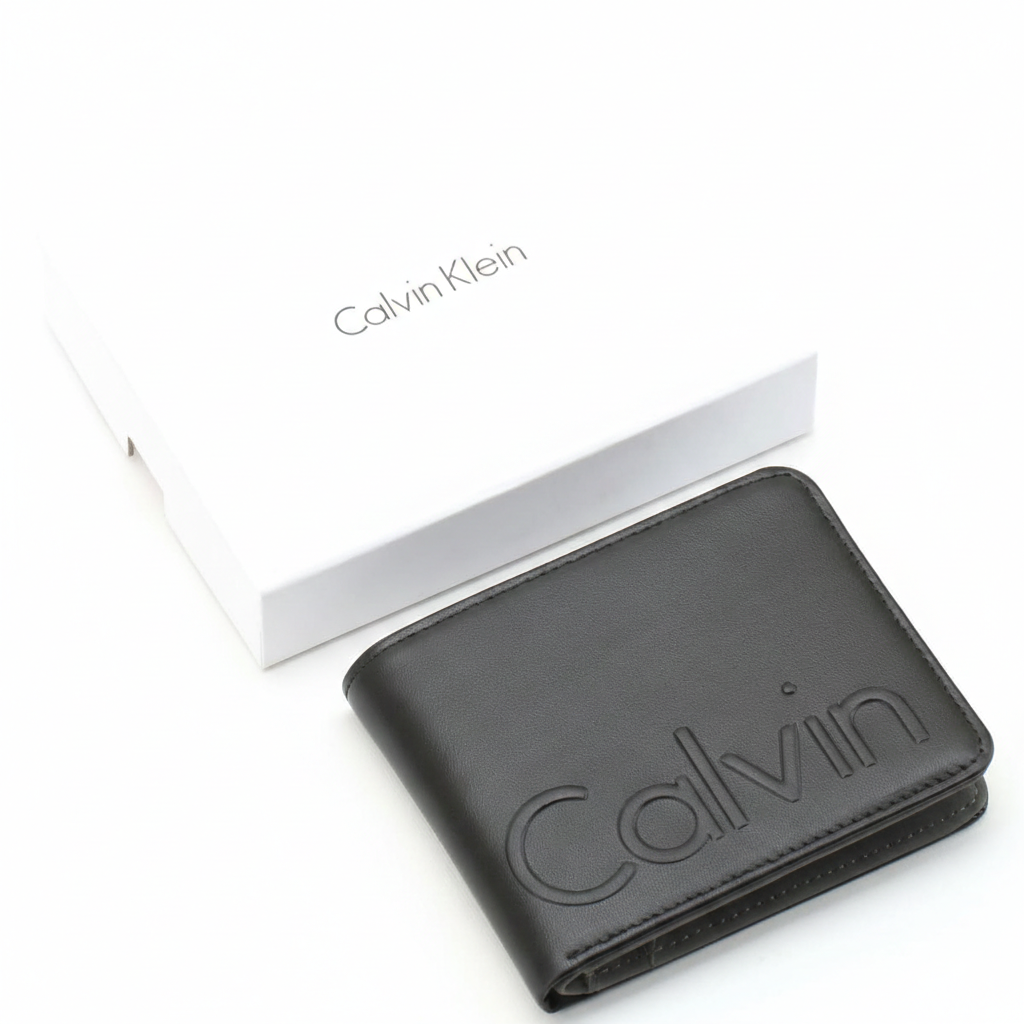 A closed Calvin Klein men's black leather wallet featuring a large debossed Calvin logo, placed next to its matching closed white branded gift box
