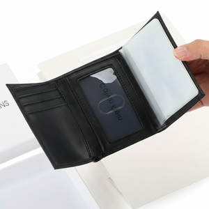 Fully open interior view of a Calvin Klein men's black leather wallet showcasing a practical tri-fold design with card slots on the left, a center clear ID window, and an additional clear plastic sleeve on the right