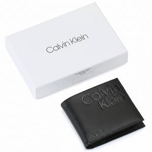 A closed Calvin Klein Jeans men's black genuine leather wallet featuring a large debossed logo, placed elegantly next to its matching closed white branded gift box