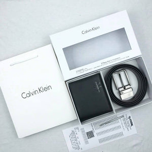 Complete Calvin Klein Jeans men's 3-piece gift set including a black leather wallet, reversible belt, and keychain, shown with luxury branded packaging and shopping bag