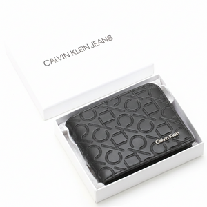 Calvin Klein men's black wallet with embossed monogram logo pattern and silver metal branding inside a white Calvin Klein Jeans gift box