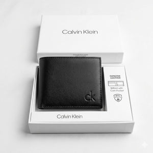Top-down studio product photography of the Calvin Klein mirror original smooth black leather wallet neatly resting inside its open custom white branded gift box