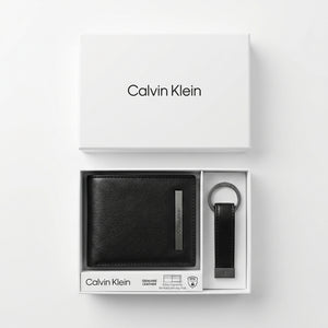 Top-down studio product photography of the Calvin Klein mirror original smooth black leather wallet and keychain set neatly resting inside its open white branded gift box