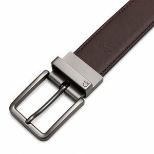 Live close-up photograph showcasing the rich brown genuine leather side of the Calvin Klein mirror original reversible belt next to the silver buckle hardware