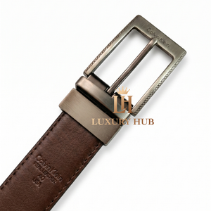 Detailed close-up of the Calvin Klein brushed metal buckle with precision-engraved brand logo