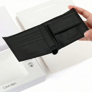 Man holding open Calvin Klein wallet showing card slots and bill compartment