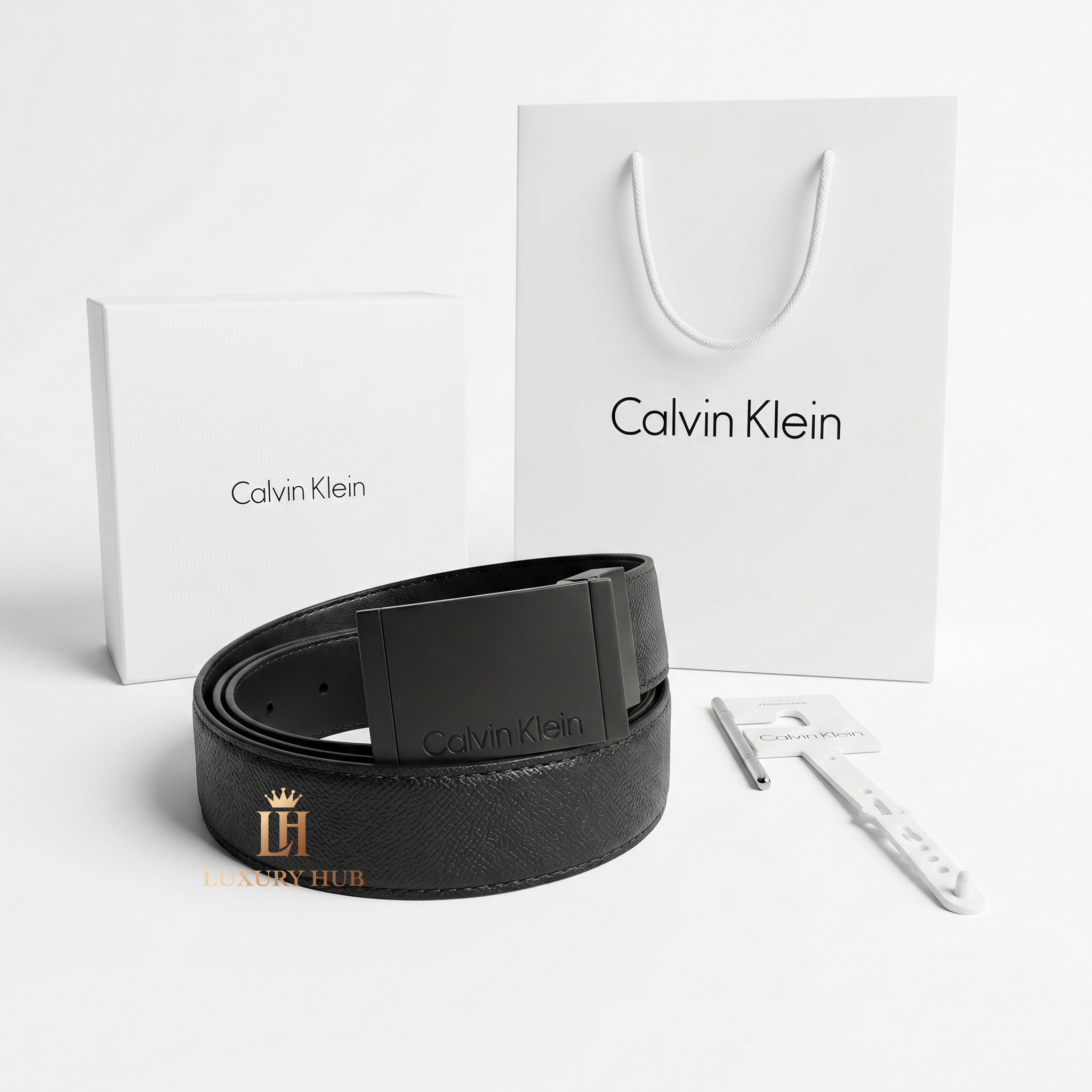 Professional standing view of the Calvin Klein black leather belt with matte buckle alongside original designer packaging