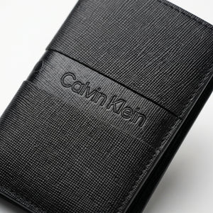 Macro close-up view showing the high-quality saffiano leather texture and precision engraved Calvin Klein center logo