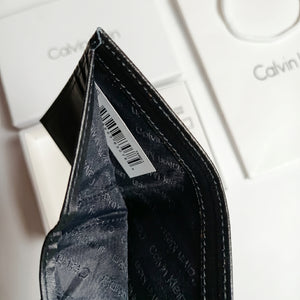 Close-up inside view of the Calvin Klein wallet showing the currency compartment, barcode tag, and premium branded lining