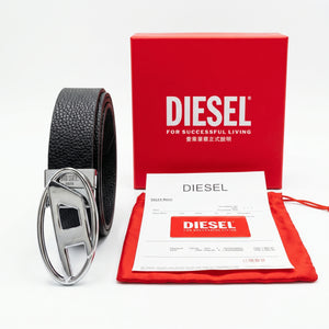 Full premium packaging presentation of the Diesel mirror original pebbled black leather belt alongside its red gift box, matching dust bag, branded card, and store receipt with silver buckle