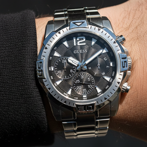 Man wearing Guess Commander GW0056G1 silver watch with a casual military jacket style
